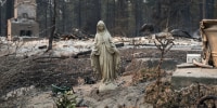 A statue of the Virgin Mary in front of a burned home in the Balboa neighborhood of Spokane, Wash., on Aug. 2, 2026.
