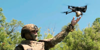 In this photo taken from video released by Russian Defense Ministry press service on Thursday, Sept. 19, 2024, a Russian serviceman launches a drone at an undisclosed location in Ukraine.