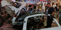 Syrian security personnel inspect damaged vehicles at the site of an explosion in the Jaramana , Syria.