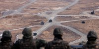 Army soldiers watch a joint live-fire exercise drill.