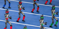 Humanoid robots walk in procession on a blue track