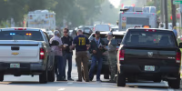 Law enforcement officials investigate the scene of a mass shooting at a Dollar General store, Saturday, Aug. 26, 2023, in Jacksonville, Fla.