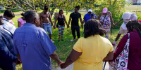 People gather for a prayer near the scene of a mass shooting in Jacksonville, Fla., on Aug. 26, 2023.