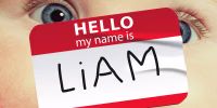 Photo illustration of a close-up of a baby's face; overlaid with a "Hello my name is Liam" sticker