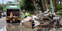 Waste Management employees pick up storm debris