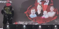 A Hamas militant stands on a stage with the coffins of what it said were the four deceased Israeli hostages it handed over to the Red Cross on Thursday.