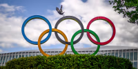 A crow flies above the Olympics Rings.