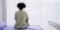 Lonely patient sitting on the hospital bed