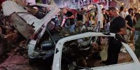 Syrian security personnel inspect damaged vehicles at the site of an explosion in the Jaramana , Syria.