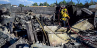 A firefighter works on the remains of a home burned by the Hawk Fire.