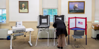 A voter casts their ballot at the Wenham Museum