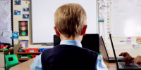 Young student in classroom using laptop  