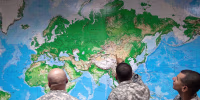 Soldiers look at a world map as they wait to board a flight in Manas, Kyrgyzstan, on the way home after completing a deployment in Afghanistan, in August 2011.