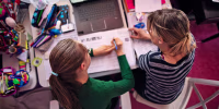 Image: Mother is helping daughter with homework in her room.