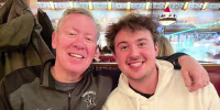Michael Kosnar smiles for a photo next to his son, with an arm over his shoulder