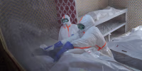 Health workers prepare to transfer the body