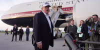 Donald Trump speaking to reporters on a tarmac.