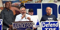 Image: Jose Palma speaking into a microphone and standing at a podium