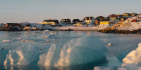 Residential houses overlooking broken sea ice in Greenland.