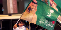 A child waves a flag of Saudi Crown Prince Mohamed Bin Salman