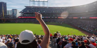 A woman cheers from the stands during a major league baseball game.
