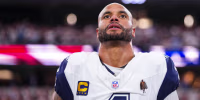 ARLINGTON, TX - SEPTEMBER 20: Dak Prescott #4 of the Dallas Cowboys looks on from the sideline during the national anthem prior to an NFL football game against the Washington Commanders at AT&T Stadium on September 20, 2026 in Arlington, Texas. (Photo by Cooper Neill/Getty Images)
