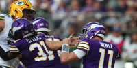 MINNEAPOLIS, MINNESOTA - SEPTEMBER 13: Lukas van Ness #90 of the Green Bay Packers grabs the face mask of Carson Wentz #11 of the Minnesota Vikings in the third quarter of a game at U.S. Bank Stadium on September 13, 2026 in Minneapolis, Minnesota. (Photo by Adam Bettcher/Getty Images)