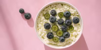 Cottage cheese with blueberry fruits on pink table in bright sunlight