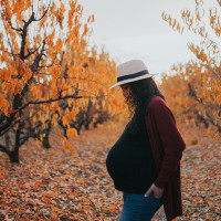 Pregnant Woman Standing Amidst Trees Against Sky During Autumn