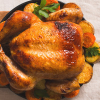 Fall thanksgiving table with roasting chicken or turkey on light tablecloth