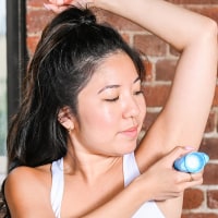 Woman putting on deodorant