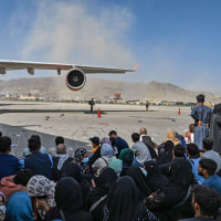Afghans wait to leave the airport in Kabul on Aug. 16, 2021.