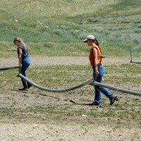 Image: Clarice Steg, left, and Maggie Higgins carry irrigation pipes at the ranch. Trinity Teen Solutions sent Higgins’ parents this photo as part of an update on her time at the ranch.
