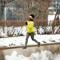 Young African woman training outdoors in bad weather