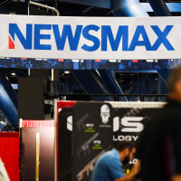 Signage for the Newsmax conservative television broadcasting network is displayed at a broadcast TV booth at the National Rifle Association (NRA) annual meeting at the George R. Brown Convention Center, in Houston, Texas on May 28, 2022.