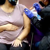 A woman receives a Pfizer vaccination booster shot in Los Angeles