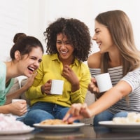 Best friends drinking tea and laughing at home
