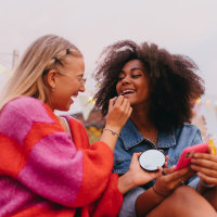 Generation z girl friends hanging out together outdoors in the city. 