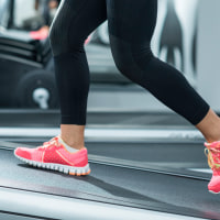 Person wearing pink shoes walking on an inclined treadmill