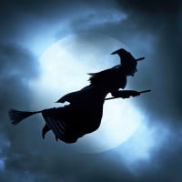 Witch flying on broom on spooky Halloween night.