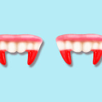 Vampire fangs teeth gummies on blue background.