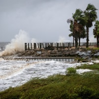 Waves impact a house seawall