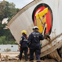 Members of the FEMA Urban Search and Rescue Task Force search a flood-damaged area with a dog along the Swannanoa River on Oct. 4, 2024 in Asheville, N.C.