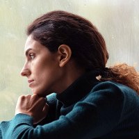 Side view thoughtful, sad woman looking out rainy window.