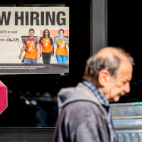 A "NOW HIRING" sign at a window.