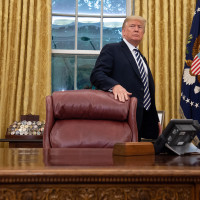 Then President Donald Trump stands behind the Resolute Desk in 2018.