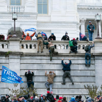 Trump supporters climb the west wall of the the Capitol