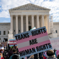 Transgenders rights supporters rally outside of the Supreme Court, a sign is held saying "Trans Rights Are Human Rights"
