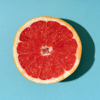 Grapefruit against vibrant blue background.