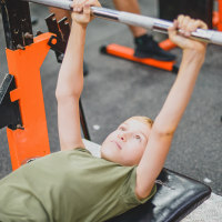 Boy in the gym lifting weights.